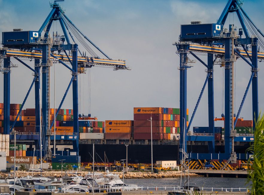 Busy industrial port showcasing cargo cranes and colorful shipping containers.